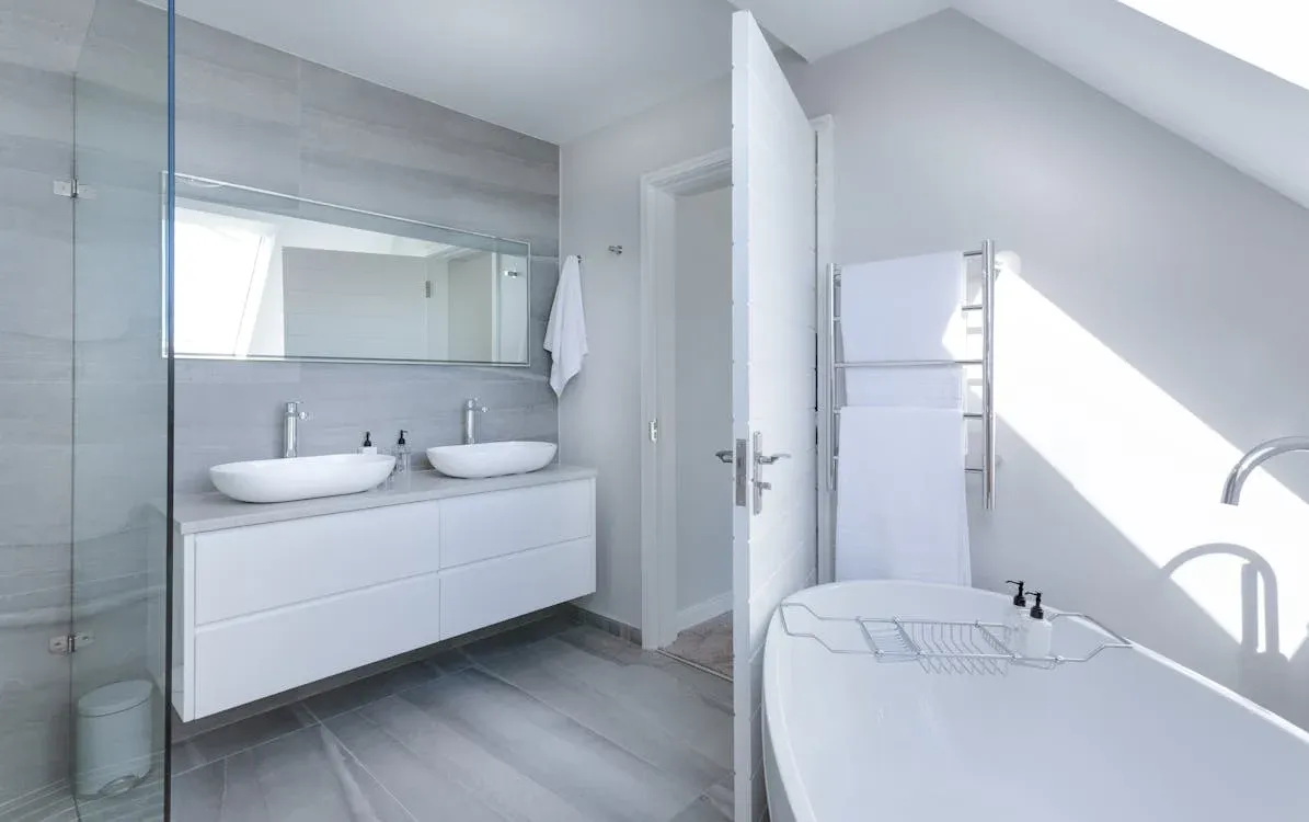 Modern luxury bathroom with dual sinks, large mirror, and walk-in shower