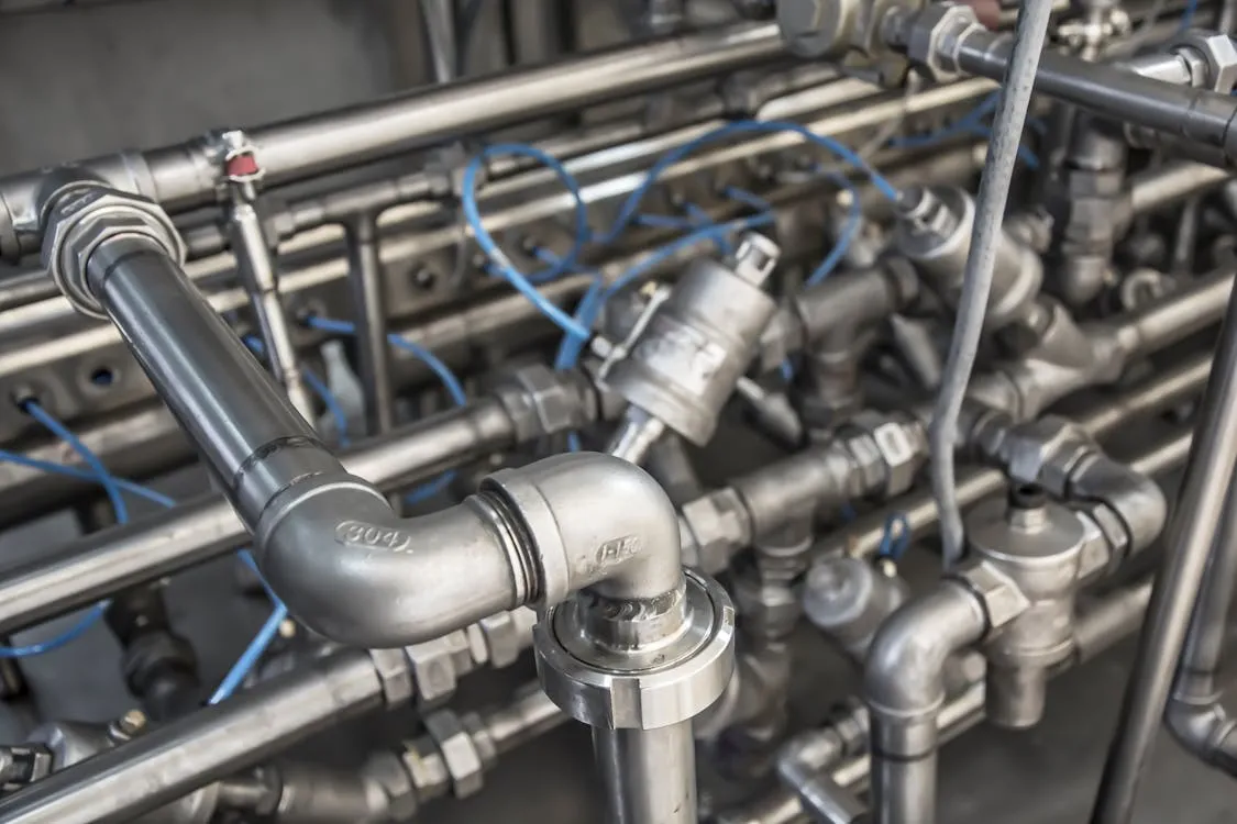 Professional plumber inspecting residential plumbing system with metal pipes